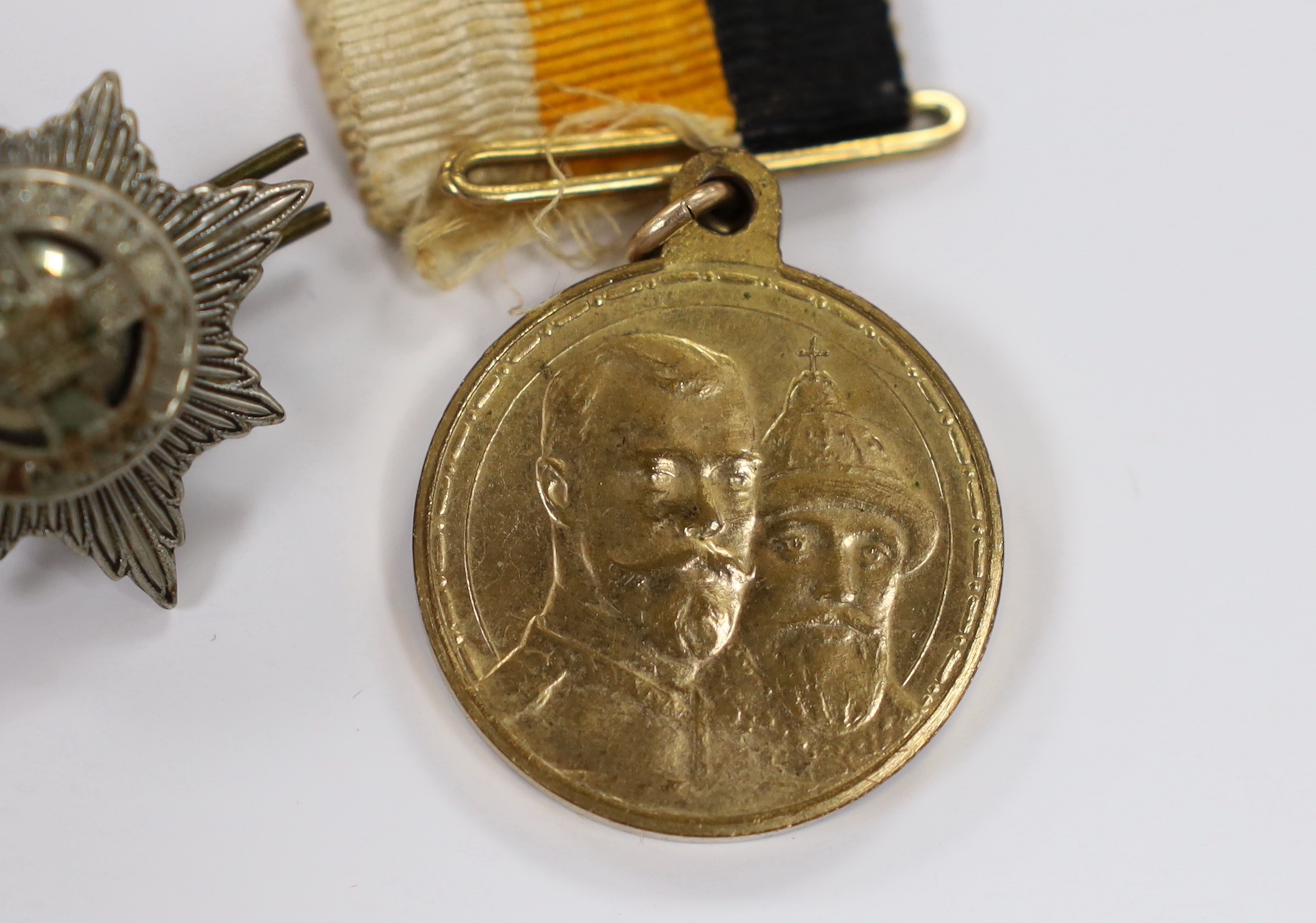 A Russian commemorative House of Romanov medal and a regimental clasp, 1922